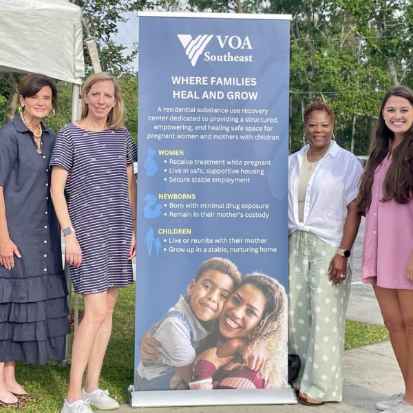 Members of VOA Southeast and Humana standing around a banner about substance use recovery