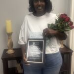 Woman holding roses and a plaque