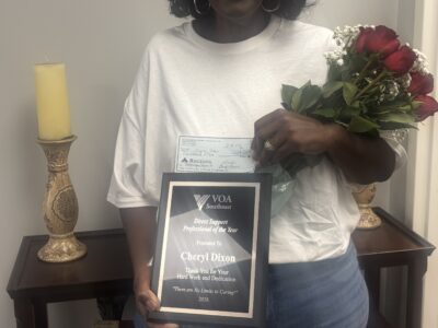 Woman holding roses and a plaque